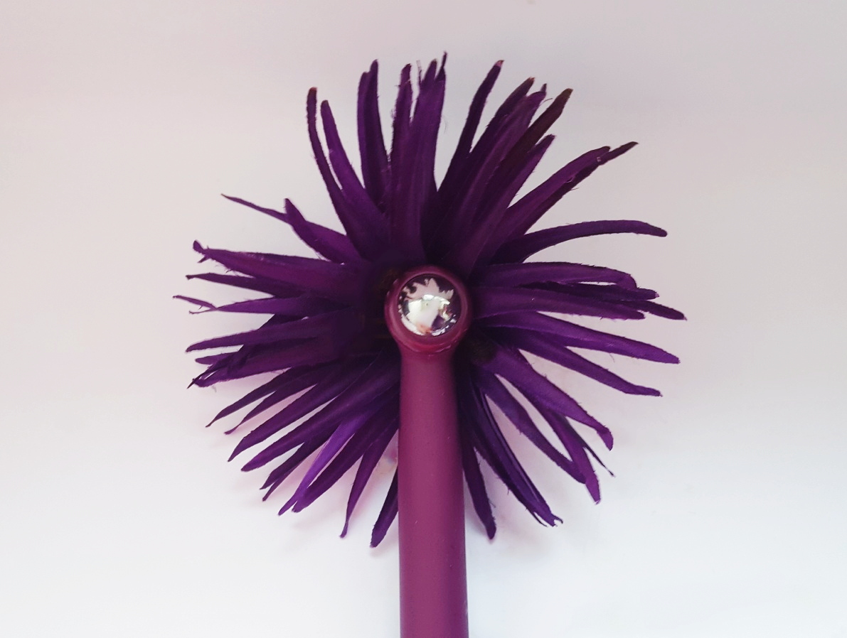 Image of the Maia Roxie Crystal Gem Lipstick Vibrator Storage Pouch with vibrator and its lid on top of it.